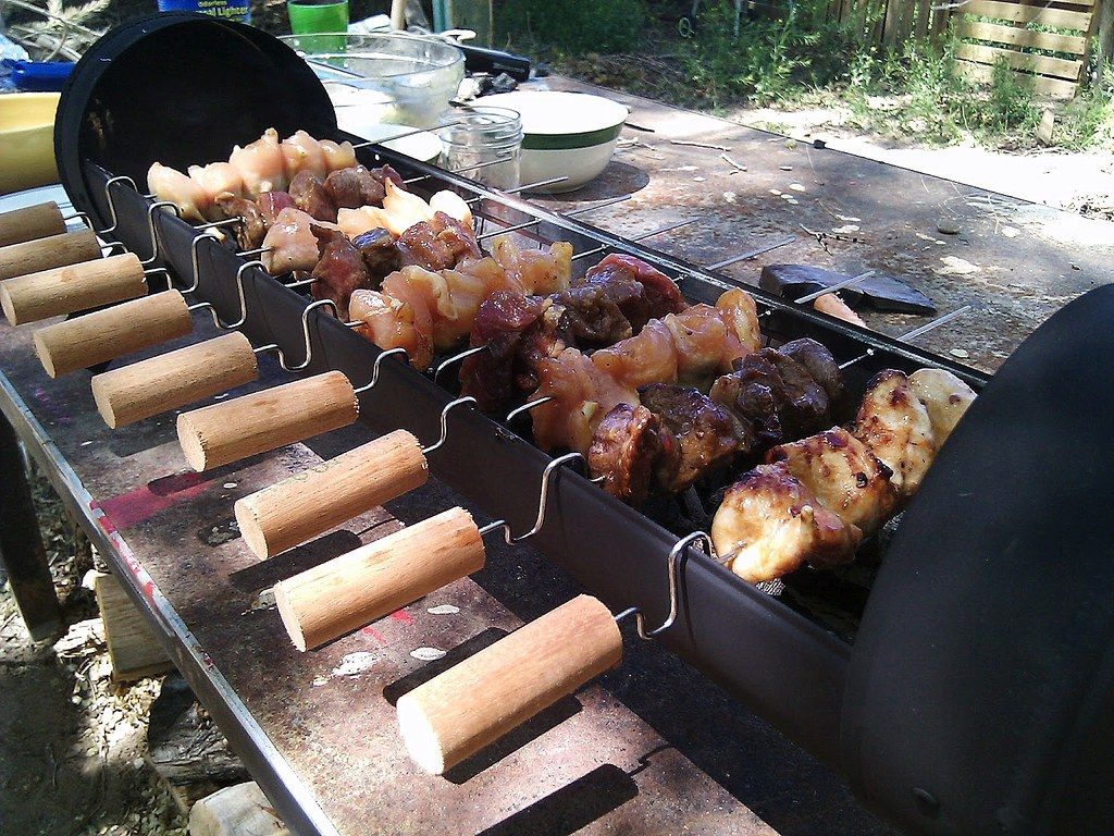 Chef turning yakitori skewers over the charcoal grill